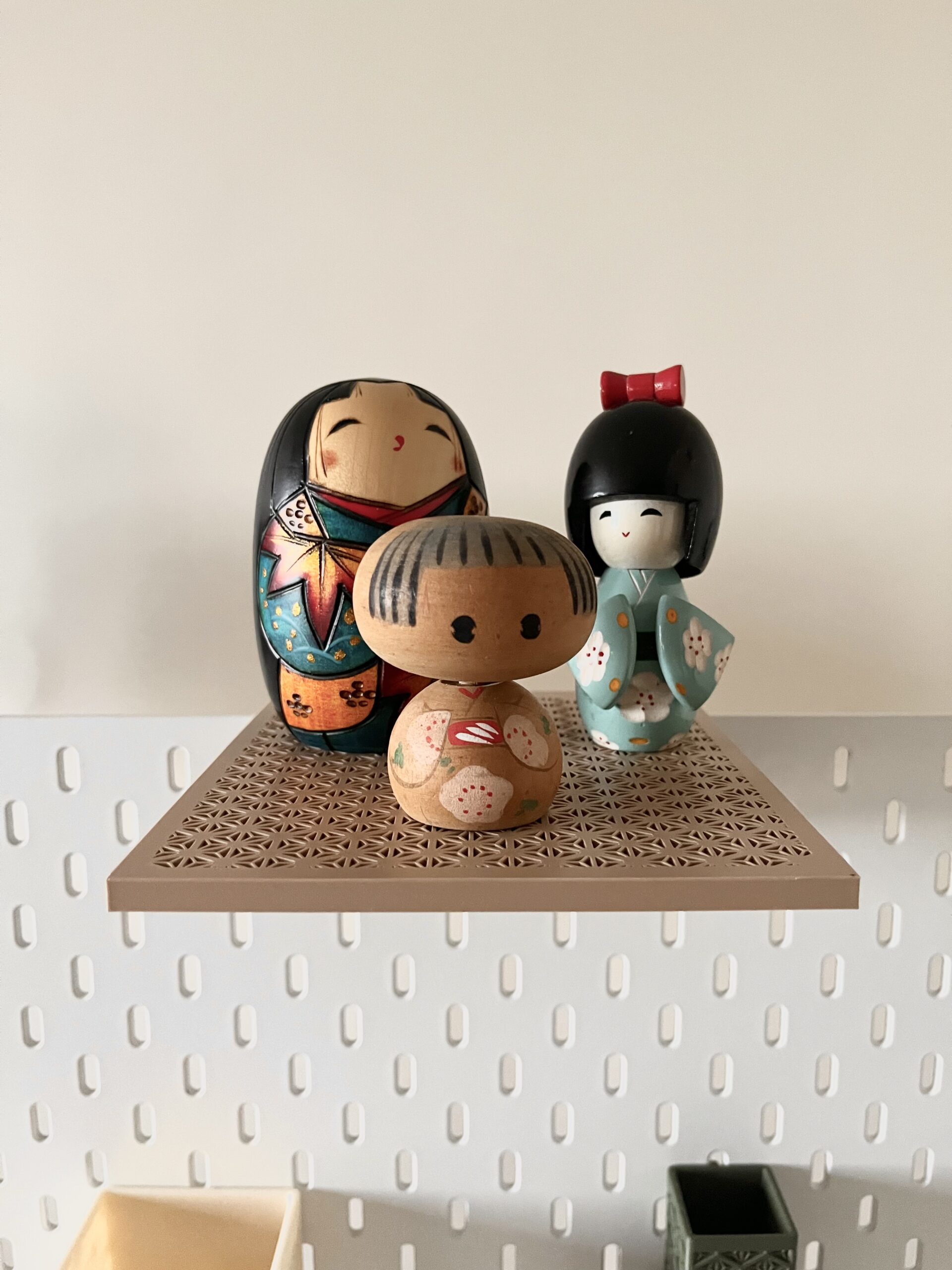 Laleczki Kokeshi na wiszącej półce